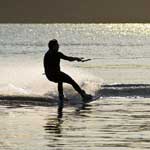 Waterskiier at sunset on a mountain lake